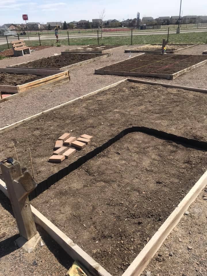 Angie's plot is ready to plant with dark brown dirt and wooden boarder