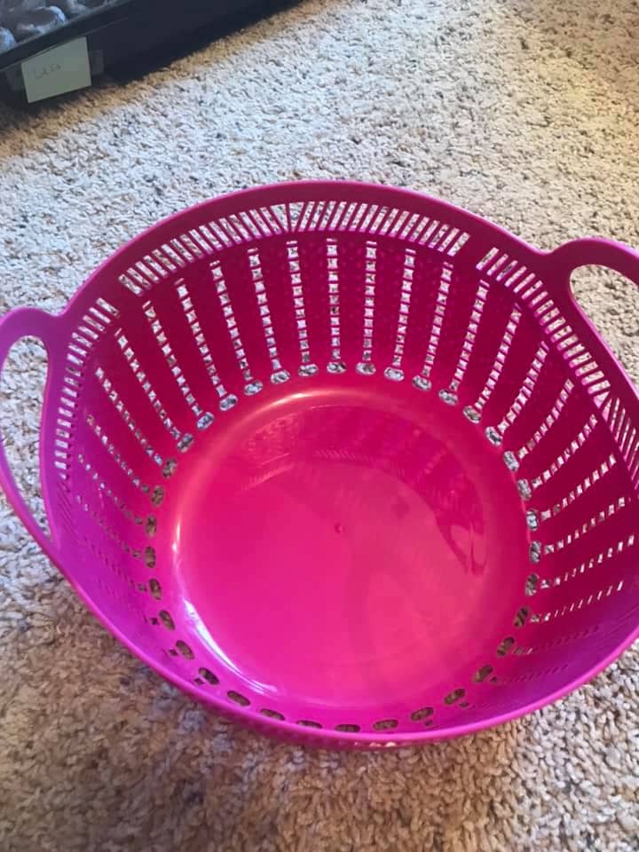 A pink basket with holes is perfect for garden harvests
